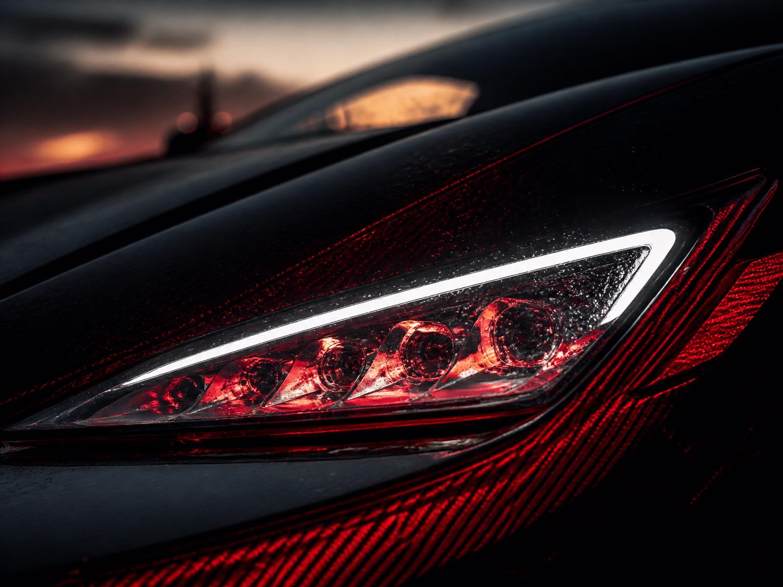 Macro close-up of a luxury car LED headlight with red reflection